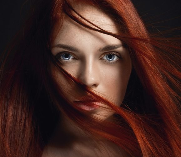 Sexy beautiful redhead girl with long hair. Perfect woman portrait on black background. Gorgeous